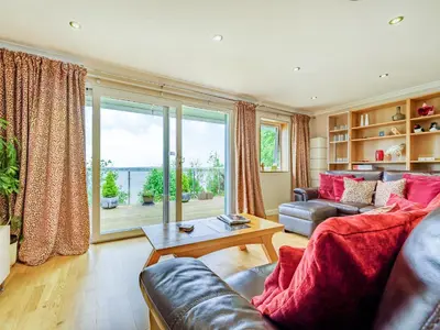 a living room with a couch and a large window at Solway Cottage in Bowness-on-Solway