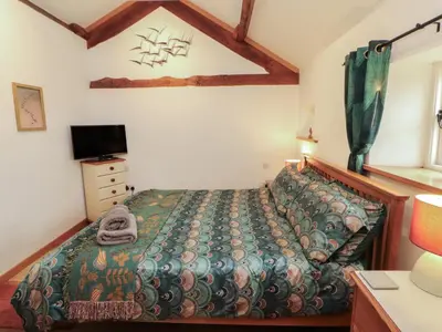 a bedroom with a bed and a tv in it at Sonya's Cottage in Anthorn