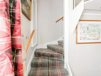 a stairway with a plaid stair runner at The Mews Flat in Dalswinton