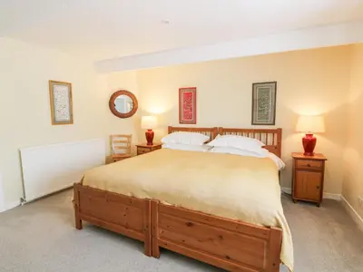 a bedroom with a large bed and two lamps at The Mews Flat in Dalswinton