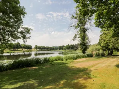 a view of a river with trees and a field at The Mews Flat in Dalswinton