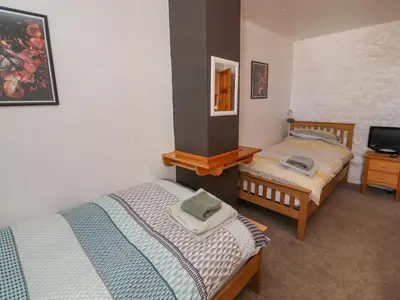 a bedroom with two beds and a tv in it at Mellfell Cottage in Watermillock