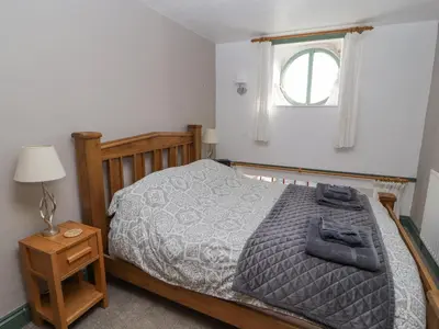 a bedroom with a bed and a window at Mellfell Cottage in Watermillock