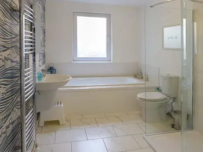 a bathroom with a tub and a toilet and a sink at Fish House in Kirkcudbright