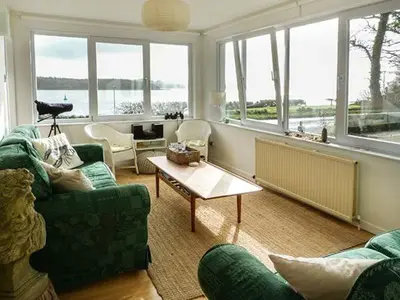 a living room with a green couch and a table at Fish House in Kirkcudbright