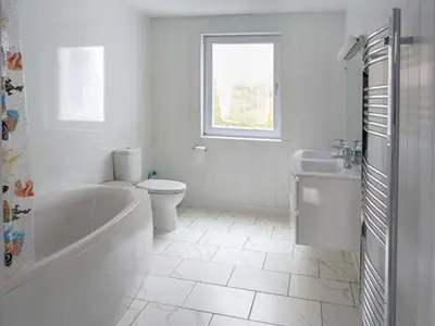a white bathroom with a tub and a toilet and a sink at Fish House in Kirkcudbright