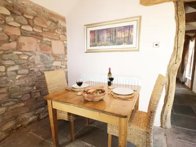 a dining room with a wooden table and chairs at Faraway Cottage in Kirklinton