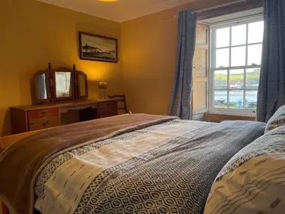 a bedroom with a bed and a window at The Pink House in Isle of Whithorn