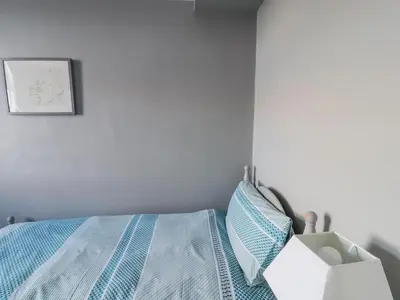 a bedroom with a bed with a blue comforter at Greenmantle in Skinburness