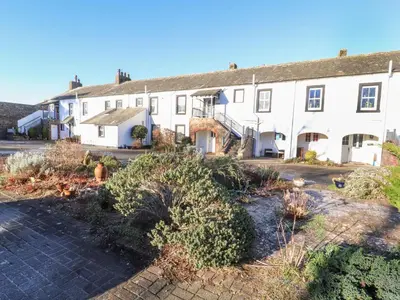 a large white house with a lot of plants at Greenmantle in Skinburness