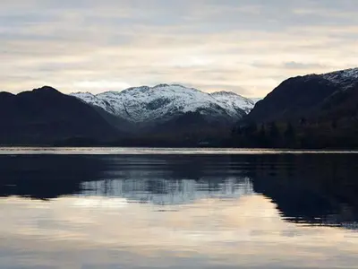 a large body of water with snow covered mountains at Littlebeck in Rosthwaite