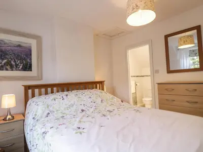 a bedroom with a bed with a floral bedspread at 1 Rubby Banks Road in Cockermouth
