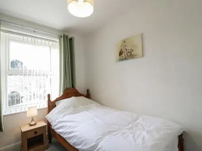 a bedroom with a bed and a window at 1 Rubby Banks Road in Cockermouth