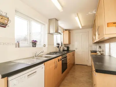 a kitchen with a sink and a stove at 1 Rubby Banks Road in Cockermouth