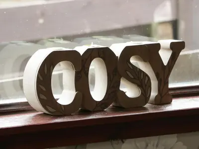 a wooden wordvp sitting on a window sill at Torkeld Holiday Cottage in Garlieston