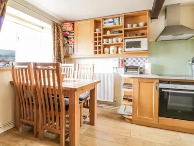 a kitchen with a wooden table and chairs at Barn Roost in Uldale