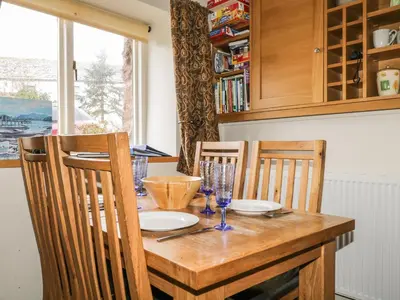 a dining room table with two chairs and a wooden table at Barn Roost in Uldale