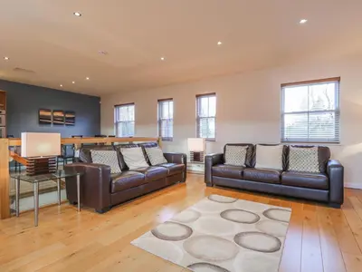 a living room with two leather couches and a table at Wrenville in Keswick