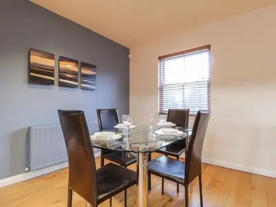 a dining room with a glass table and chairs at Wrenville in Keswick