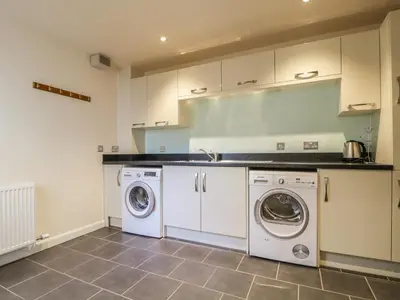a kitchen with a washing machine and a washer and dryer at Wrenville in Keswick