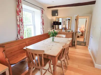 a dining room with a wooden table and chairs at Mell View Cottage in Watermillock