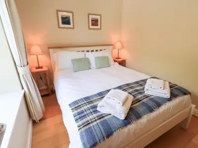 a bedroom with a bed with towels on it at Mell View Cottage in Watermillock