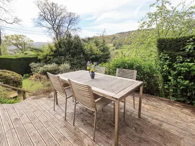 a wooden table and chairs on a wooden deck at Mell View Cottage in Watermillock