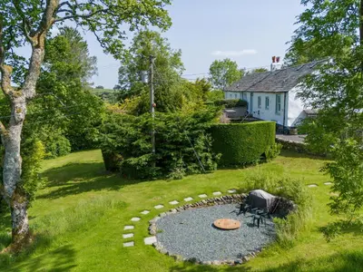 a garden with a fire pit in the grass at Mell View Cottage in Watermillock