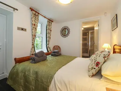 a bedroom with a bed with two teddy bears on it at Coombe Cottage in Borrowdale Valley