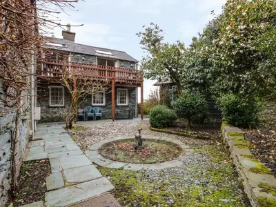 a house with a bird statue in the middle of a yard at Coombe Cottage in Borrowdale Valley