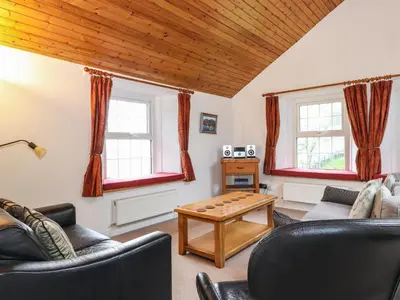 a living room with two chairs and a table at Coombe Cottage in Borrowdale Valley