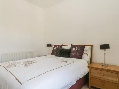 a bedroom with a bed and a wooden nightstand at Helvellyn in Keswick