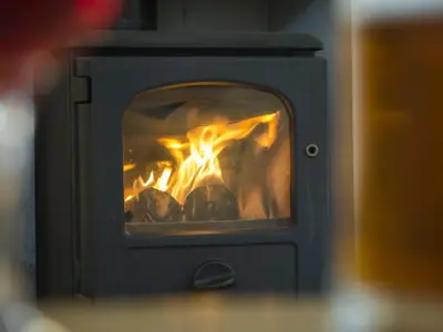a stove with a fire inside of it at Ellwood House in Caldbeck