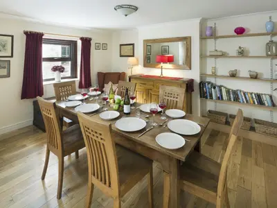 a dining room with a wooden table and chairs at Ellwood House in Caldbeck