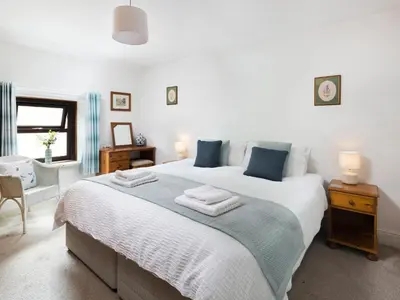 a bedroom with a large bed with towels on it at Ellwood House in Caldbeck