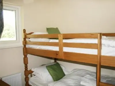 a bedroom with a bunk bed with white pillows at Whitbarrow Holiday Village Troutbeck 5 in Penruddock