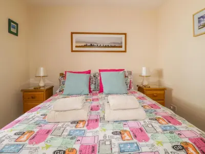 a bedroom with a large bed with two lamps at Castlerigg in Keswick