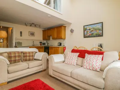 a living room with two couches and a kitchen at Castlerigg in Keswick
