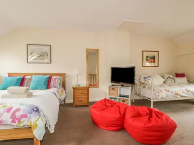 a bedroom with two beds and a flat screen tv at Castlerigg in Keswick