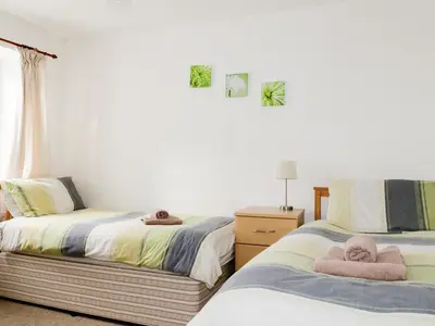 two beds with towels on them in a bedroom at Fountain Cottage in Keswick