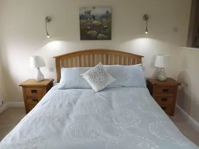 a bedroom with a white bed with two night stands at Eribel Cottage in Threlkeld