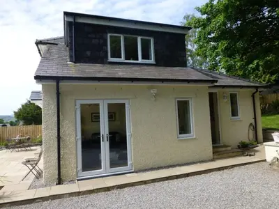 a small house with a door on a patio at Eribel Cottage in Threlkeld