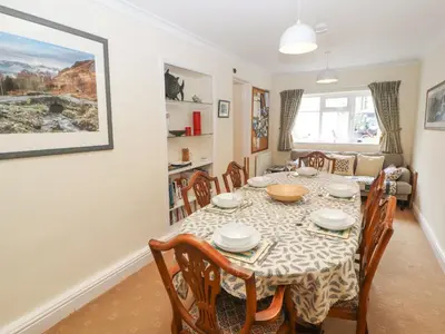 a dining room and living room with a table and chairs at White House in Keswick