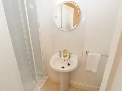a white bathroom with a sink and a mirror at White House in Keswick