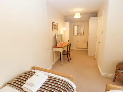 a bedroom with a bed and a desk and a table at White House in Keswick