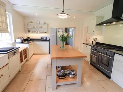 a kitchen with a vase of flowers on a table at Little Ellers in Portinscale