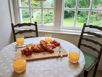 a table with a breakfast of croissants and orange juice at Little Ellers in Portinscale