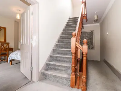 a staircase in a home with a wooden railing at Latrigg House in Keswick
