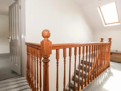 a wooden staircase with a wooden railing in a house at Latrigg House in Keswick