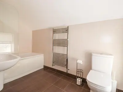 a bathroom with a white toilet and a sink at Latrigg House in Keswick